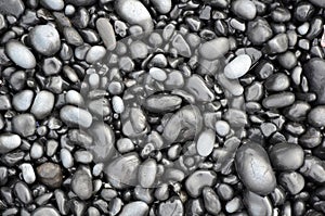 Black lava pebbles on beach