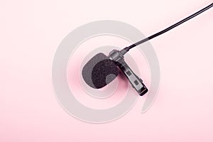 black lavalier microphone close-up on pink background photo