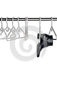 Black leather boot hanging a closet pole