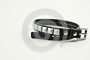 Black leather bracelet Freddie Mercury with holniten close-up on a blurred gray background