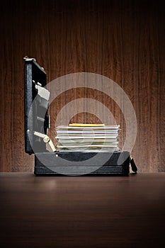 Black leather briefcase with ambitiousl stack of files