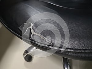 Black leather chair seats have been damaged due to deterioration. Torn to see the foam inside.