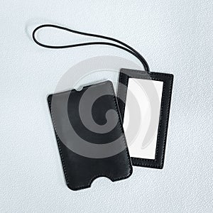 Black leather hanging tag on synthetic background. Blank name tag for your design