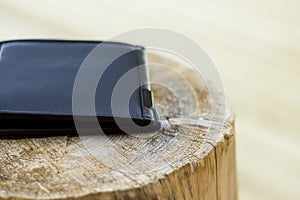 Black, leather man's wallet sitting on wood