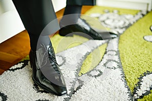 Black leather shoes on groom`s legs