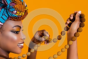 Black leather woman with bright makeup holding a beaded necklace. Traditional african accessories.
