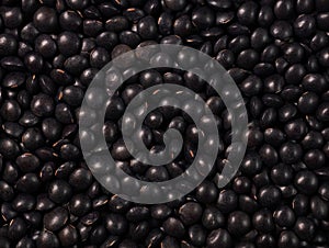 Black lentils texture food background. Dry beluga lentil grains pattern, raw dal, daal, dhal, masoor, pulse wallpaper with copy