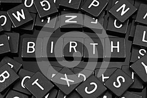 Black letter tiles spelling the word & x22;birth& x22;