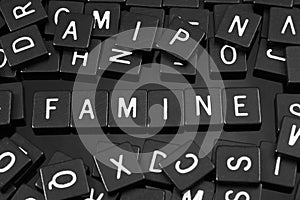 Black letter tiles spelling the word & x22;famine& x22;