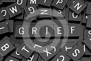 Black letter tiles spelling the word & x22;grief& x22;