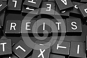 Black letter tiles spelling the word & x22;REITs& x22;