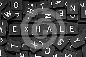 Black letter tiles spelling the word & x22;exhale& x22; photo