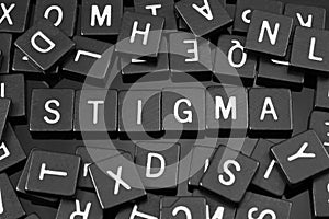 Black letter tiles spelling the word & x22;stigma& x22; photo
