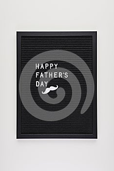 Black letterboard with white plastic letters with quote: Happy F