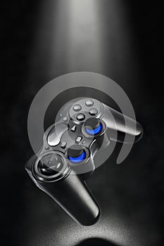 Black levitated wireless gamepad on dark background