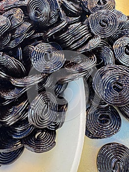 Black Licorice Wheels in White Bowl photo