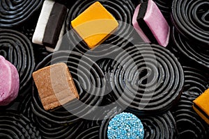 Black liquorice swirls, chewy candy and delicious dessert concept with macro close up on licorice wheels and other assorted