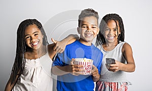 Black little boy and sister girl watching movie with pop corn