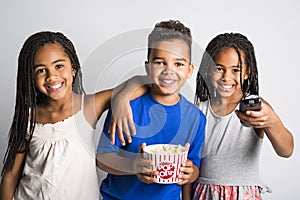 Black little boy and sister girl watching movie with pop corn