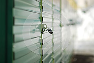 Black lock on the green doors of gate in the moscow street