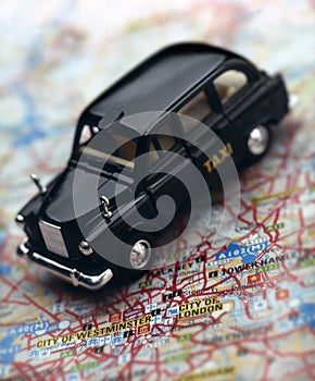 Black London taxi cab on map of London