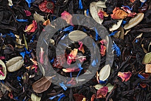 Black loose leaf tea texture with dried fruits, herbs and flower petals