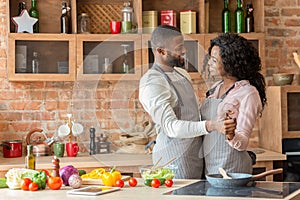 Black lovely married couple dancing in kitchen