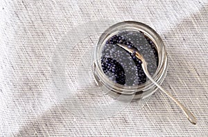Black lump fish eggs in a jar, from above