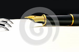 Black luxury gold plated fountain pen on open notebook with copy space