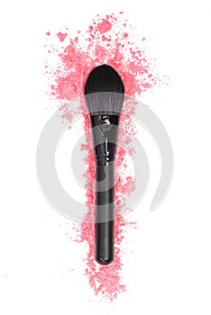 Black makeup brush and pink powder on a white isolated background.  Close-up.  View from above