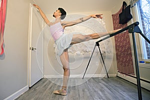 Black male ballet dancer warming up at the barre