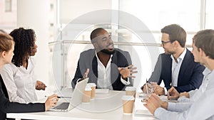 Black male boss leading corporate in team meeting