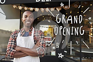 Black male business owner outside coffee shop grand opening