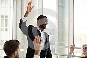 Black male coach hold teambuilding activity with workers raising photo