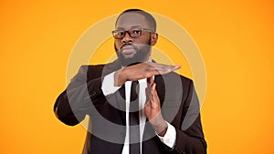 Black male in formalwear showing time out sign, interrupt negotiations, vacation