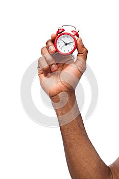 Black male hand holding red alarm clock