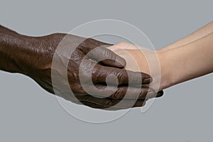 Black male hands hold white female human hands in their palms. The concept of inter-racial friendship, love, respect, and the