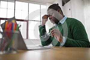 Black Male Having Sore Eyes Working On Laptop In Office