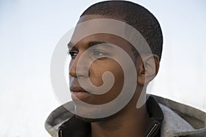 Black male model wearing a hoodie with a serious expression