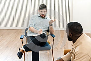 A black male patient undergoing a psychotherapy session with a counselor at a mental health clinic. Young man with