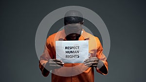 Black male prisoner holding respect human rights sign in cell, sexual harassment