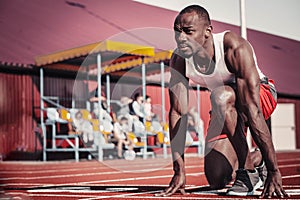 Black male runner with a purposeful look ahead at the start