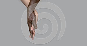 Black male and white female human hands touch palms, holding each other. The concept of inter-racial friendship and