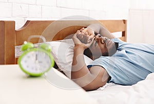 Black man in bed suffering from insomnia and sleep disorder