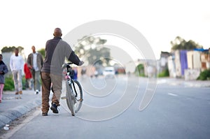 Black man with a bicycle.