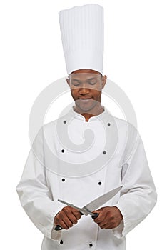 Black man, chef and sharpen knife in studio isolated on a white background. Cooking, professional and honing steel tool