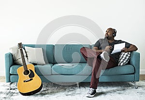 Black man composing new song on a couch photo