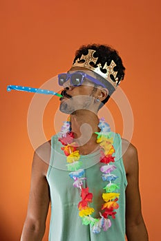 Black man in costume for carnival with pandemic mask isolated on orange background