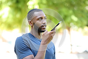 Black man dictating audio message on smart phone