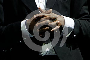 A black man in an elegant suit clasp the hands. Gestures and features of business negotiations